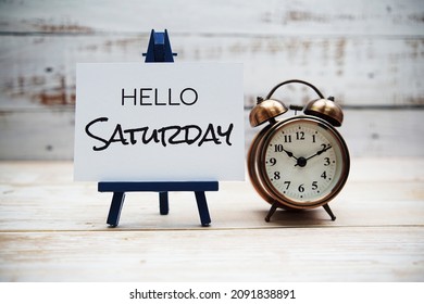 Hello Saturday Text With Alarm Clock On Wooden Background