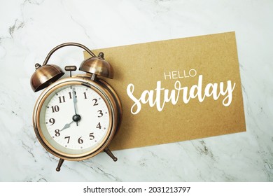 Hello Saturday Typography Text On Paper Card With Alarm Clock On Marble Background