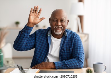 Hello. Senior Black Businessman Waving Hand Smiling To Camera Video Calling Via Laptop Computer Sitting At Desk At Workplace In Modern Office. Modern Distance Communication - Powered by Shutterstock