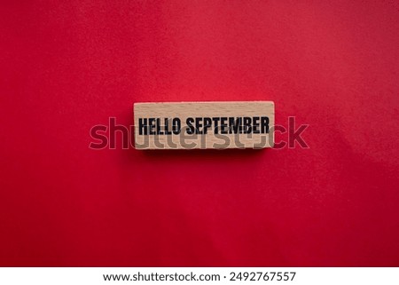 Hello september message written on wooden block with redbackground. Conceptual hello september symbol. Copy space.