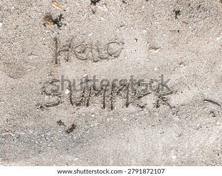 Hello Summer handwritten message in beach sand texture