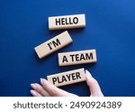 Hello I am a team player symbol. Concept words Hello I am a team player on wooden blocks. Businessman hand. Beautiful deep blue background. Business and Hello I am a team player concept. Copy space