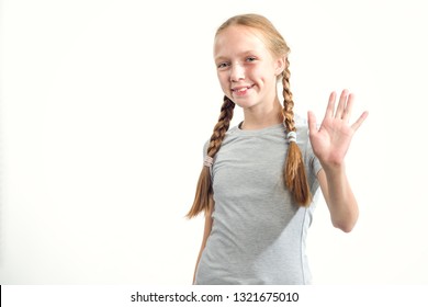 Hello! Teen girl waving her hand in greeting. Portrait of a young happy girl showing open hand and five fingers on white background.