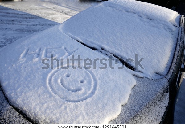 Hello winter! Snow, ice and a funny smiley on the\
hood of a car\
