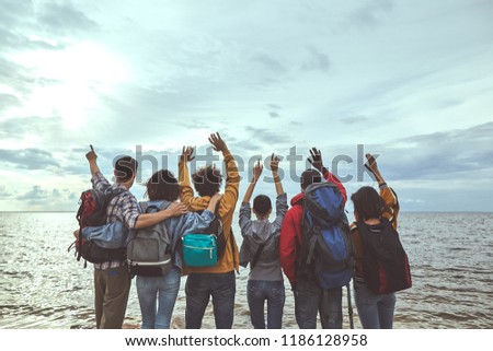Hello world. Portrait of friends greeting seaside holding their hands up