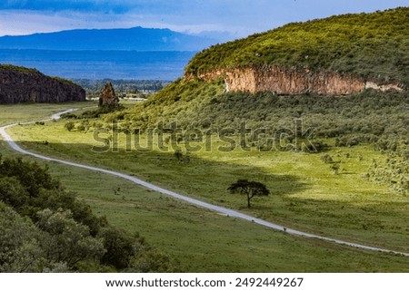 Hell's Gate National Park Gorge Escarpments Filled with greenery vegetation on a cloudy blue sky in Naivasha Great Rift Valley Nakuru City County Kenya East Africa, Kenya Landscapes Travel Documentary