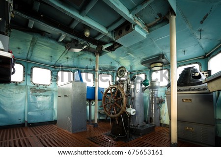 The helm and wheel in a boat cabin or war room with battle stations and instruments, consoles of old Battleship in World War 2