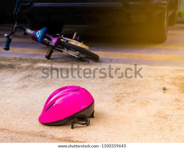 The helmet bicycle\
riders collided with a car, until the fall has been injured in the\
middle of the road\

