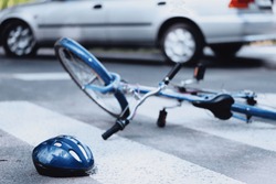 Helmet and bike lying on the road after a car hit a cyclist on a pedestrian crossing, a Transportation Photo by Photographee.eu