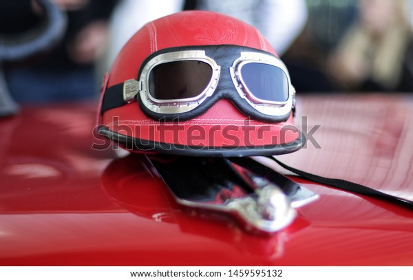 Helmet and\
goggles on the hood of a sports\
car.
