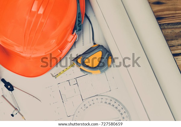 Helmet and measurement tool on blueprint,
architectural concept