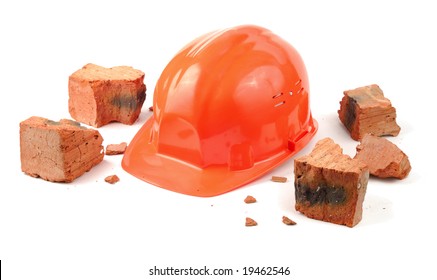 Helmet and pieces of broken brick isolated over white
