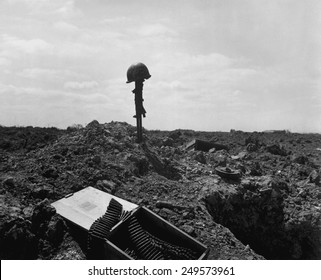 Helmet and rifle monument to a dead U.S. soldier on a shell-blasted beach of France. He was killed on D-Day during the Normandy landings, June 6, 1944, World War 2.