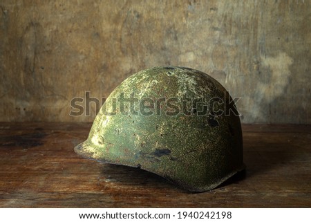 Helmet of a soldier of the Soviet army during the Second World War. on a wooden table.