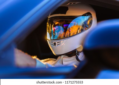A Helmeted Race Car Driver At The Wheel