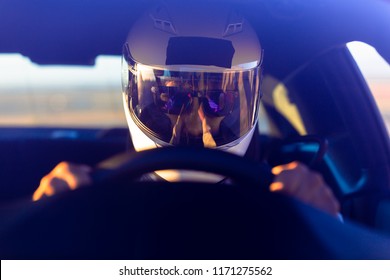 A Helmeted Race Car Driver At The Wheel