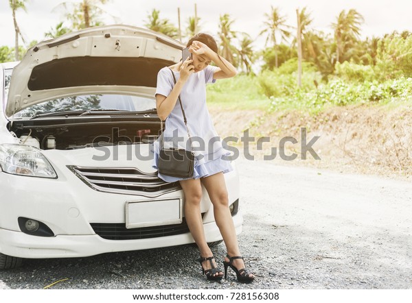 Help of car. Asian\
woman Young woman near broken car calling insurance or service\
,auto mechanic for help on countryside. road trip,\
transport,holiday and people concept \
