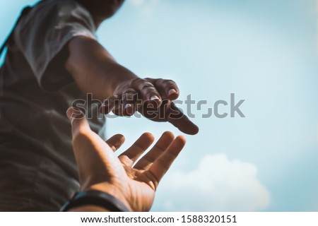 Help Concept hands reaching out to help each other in dark tone.