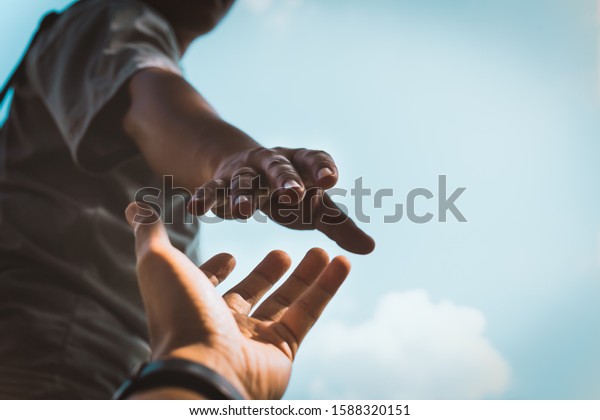 Help Concept hands reaching out to help each other\
in dark tone.