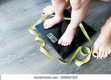 Help Fat Or Obese Child With Toddler On Weight Scale, Supervised By A Parent
