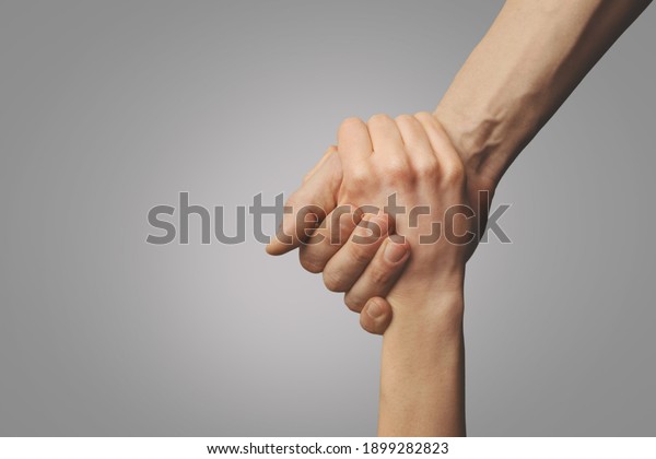 help friend through\
a tough time. rescue gesture. support, friendship and salvation\
concept. holding hands