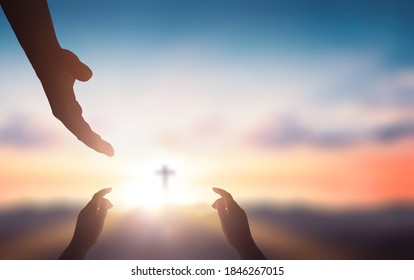  Help hand of God reaching over blurred cross on sunrise  background