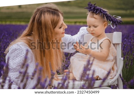 With the help of her mother, a little girl wears a lavender wreath on her head