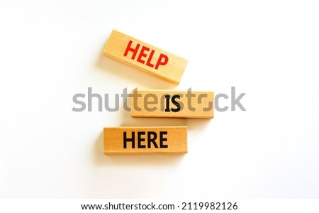 Help is here and support symbol. Concept words Help is here on wooden blocks on beautiful white table white background. Business, support, help is here concept. Copy space.