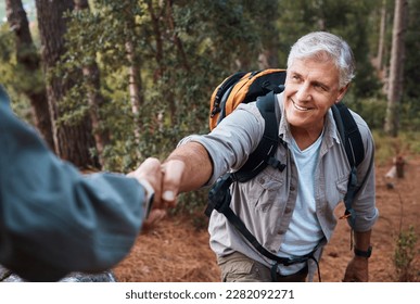 Help, holding hands and couple hiking in nature, climbing support and giving a hand. Happy, together and a person helping a senior man up a hill while on a walk in the mountains for exercise - Powered by Shutterstock