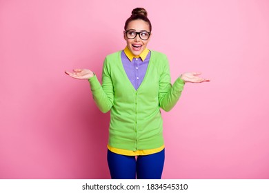 Help me pick. Photo of charming pretty clumsy girl hold palms empty space selecting between two variants beaming smiling wear spectacles colored clothes bright pink color background
