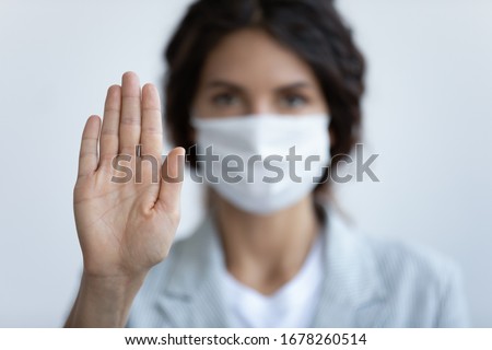 Help stop spreading globally corona virus pandemic infectious disease outbreak. On background woman in mask focus on stretched hand as symbol of keep distance avoid communication, healthcare concept