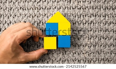Help Ukraine. hand building home with wooden blocks with Ukraine flag colors Stockfoto © 