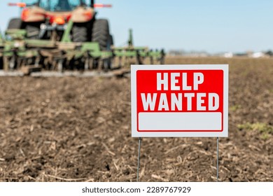Help wanted sign in farm field during spring planting season. Farm labor shortage, agriculture job market and employment concept.
