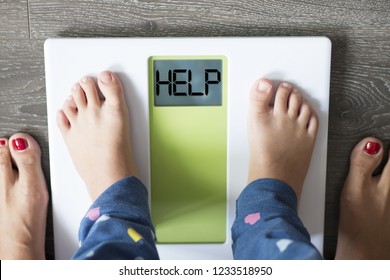 Help Word On Weight Scale Display With Child’s Feet Standing In  Front Of His Mother
