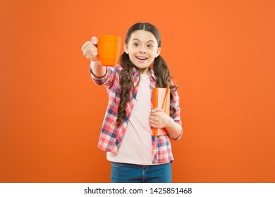 Help Yourself. Cute Schoolgirl Enjoying School Break On Orange Background. Little Girl Having Tea Break. Small Child Holding Book And Cup At Meal Break. Its Break Time.