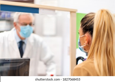 Helpful Pharmacist Wearing A Covid Coronavirus Mask Talking To A Customer