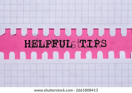 Helpful tips message written on ripped torn paper on pink background. Conceptual helpful tips symbol. Copy space.