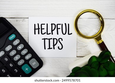 Helpful Tips text message with calculate and magnifying glass top view on wooden background