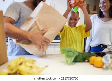 Helping the family to make supper. Shot of a family unpacking the groceries in the kitchen at home. - Powered by Shutterstock