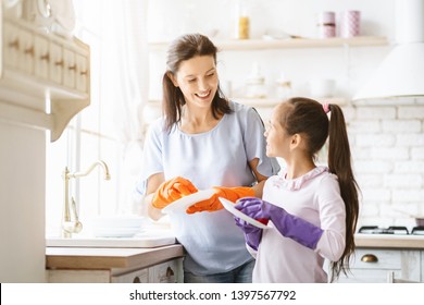 Helping hand. Cute Teenage Girl Help Her Mother In Washing Dishes At Family Kitchen