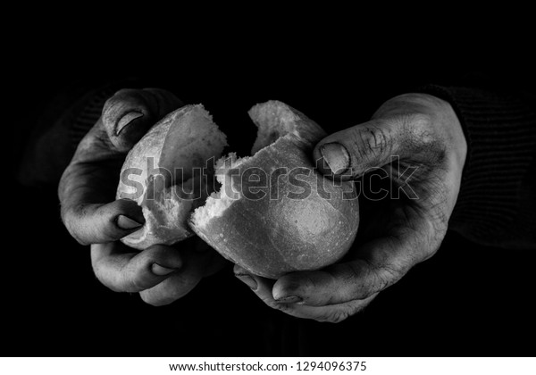 Helping hand giving\
a piece of bread. Poor Man dividing and sharing Bread, Helping Hand\
Concept. Black and\
white