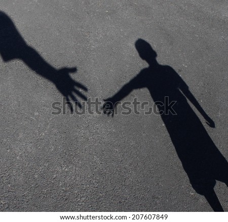 Helping Hand with a shadow of an adult hand offering help or therapy to a child in need as an education concept of charity towards needy kids and teacher guidance to students who need tutoring.