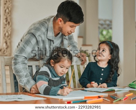 Helping my daughters develop. a young father helping his daughters with their homework.