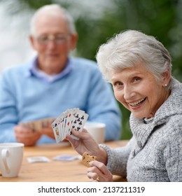 Helping the time pass with card games. Two seniors playing cards together. - Powered by Shutterstock