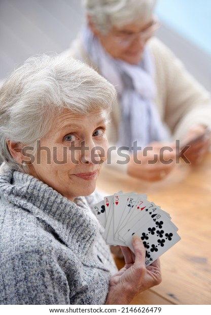 Helping the time pass with card games.\
Shot of senior citizens playing cards\
together.