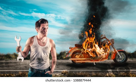 Helpless Man Holding A Wrench With His Motorcycle On Fire In The Background. Needs Help To Repair The Motorbike. 
