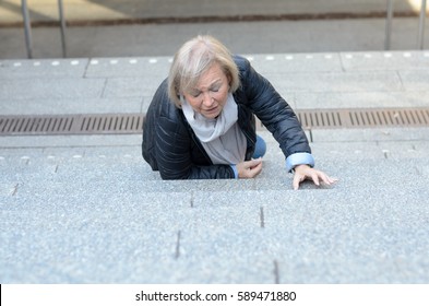 Helpless senior woman falling down steps and looking down