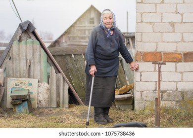 helpless sick elderly woman holding onto a crutch