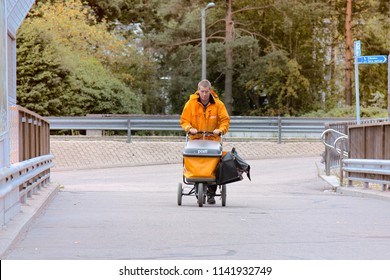 HELSINKI, FINLAND - AUGUST 21, 2017: Postman In Uniform With Bag And Cart Delivering Mail, Delivery Service Parcels And Letters