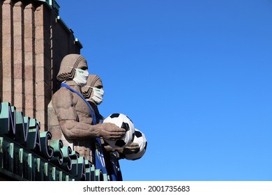 Helsinki, Finland - July 03 2021: The Statues Of The Main Railway Station Of Helsinki Are Wearing Masks And Holding A Football To Honor The EM Football Championship.